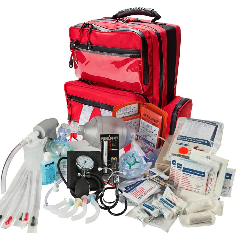 Rote Rettungstasche mit ausgebreiteten Erste-Hilfe- und Notfallmaterialien: Beatmungsbeutel (Ambu), Sauerstoffmasken und Schläuche, Blutdruckmanschette und Manometer, Guedel-Atemwegstuben, Verbandmaterialien, Spritzen und Anleitungen.
